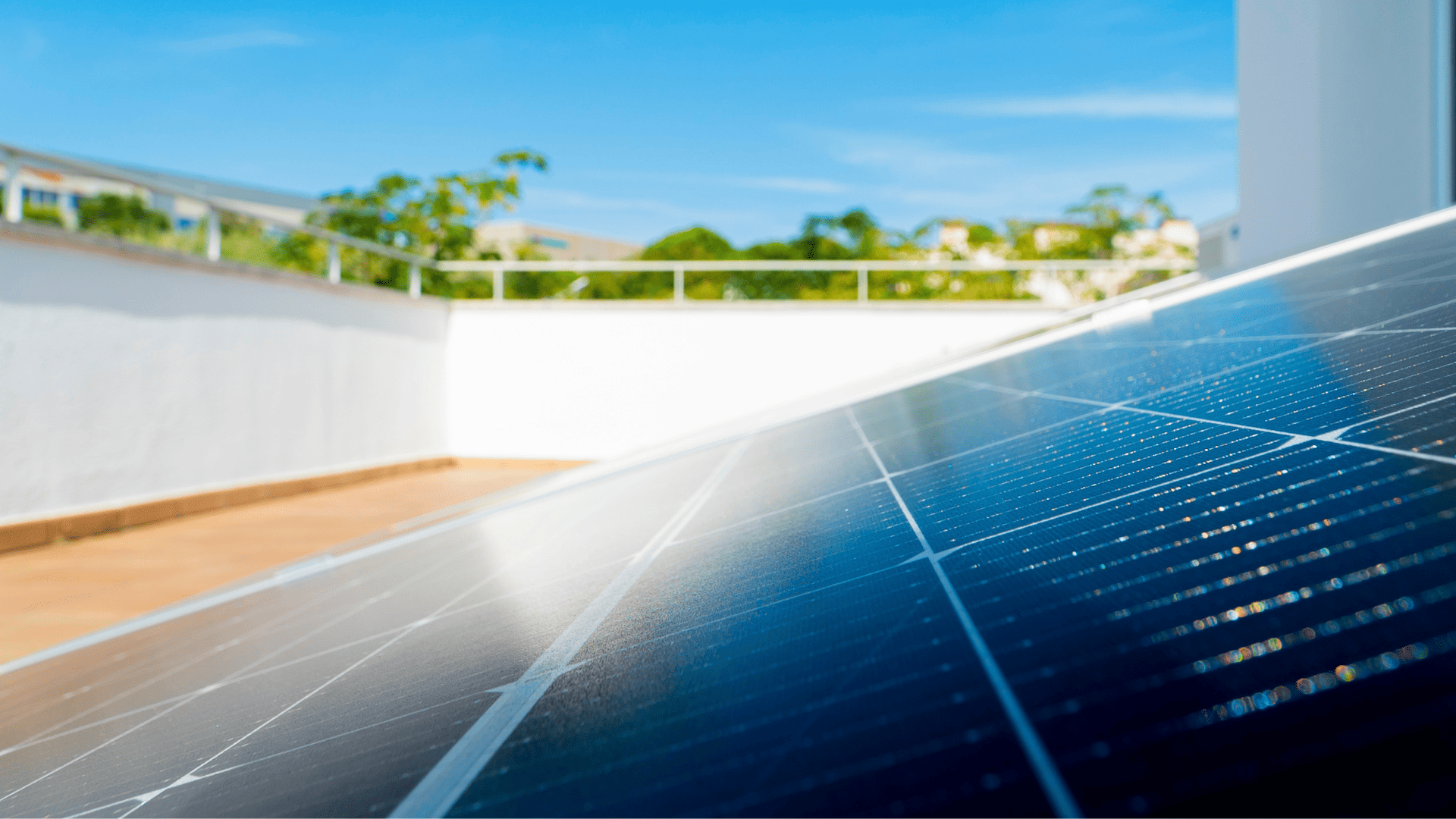 Primer plano de paneles solares instalados en una azotea, captando la luz del sol en un entorno residencial bajo cielo despejado.
