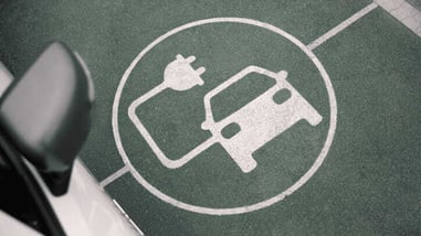 Símbolo pintado en el suelo que indica una plaza de aparcamiento para vehículos eléctricos con punto de carga