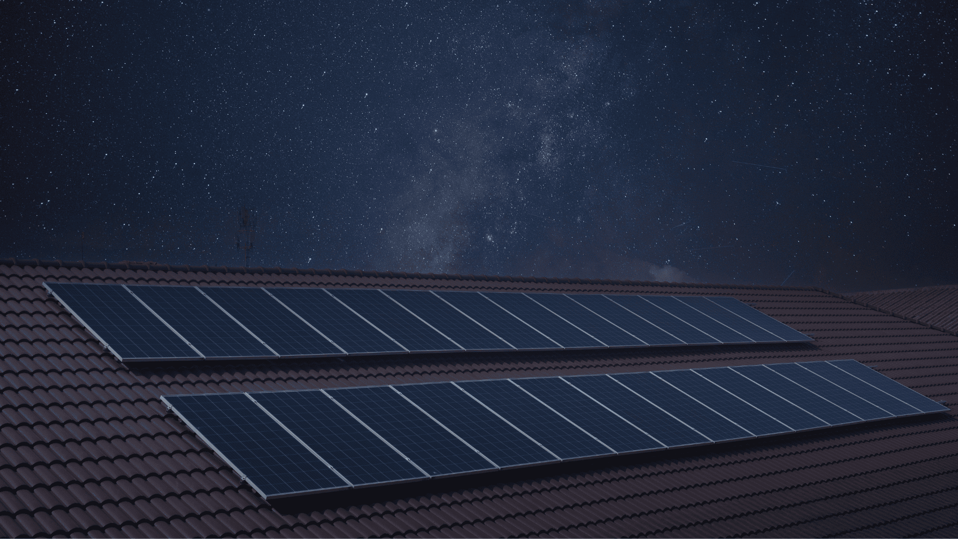Paneles solares instalados en un tejado bajo un cielo estrellado.