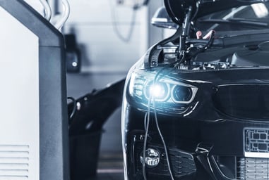 Coche eléctrico conectado a una estación de carga en un taller o garaje