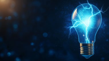 Bombilla encendida con rayos eléctricos en su interior sobre fondo azul oscuro