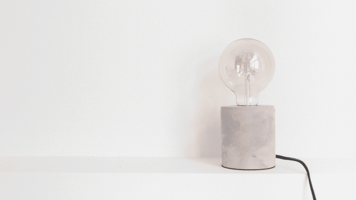 Bombilla decorativa sobre una base minimalista en un fondo blanco