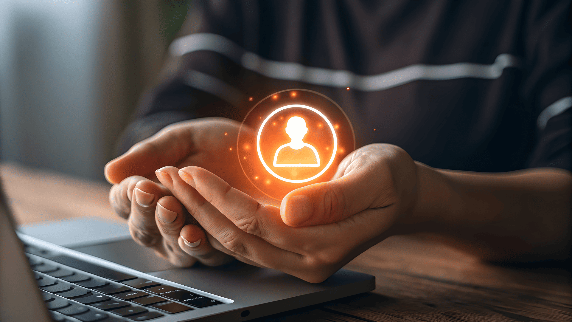 Manos protegiendo un icono digital de usuario sobre un portátil, simbolizando seguridad y protección de datos en la contratación online de servicios como la luz.