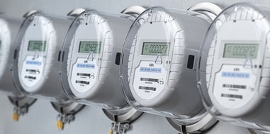 Contadores eléctricos digitales instalados en fila sobre una pared.