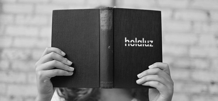 Manos sosteniendo un libro abierto con el logo de Holaluz en la portada