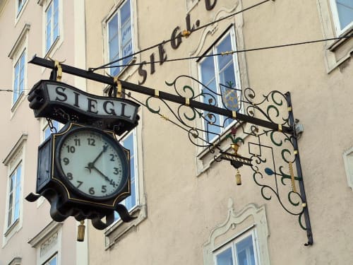 Reloj antiguo de color marrón colgado en la pared de un edificio