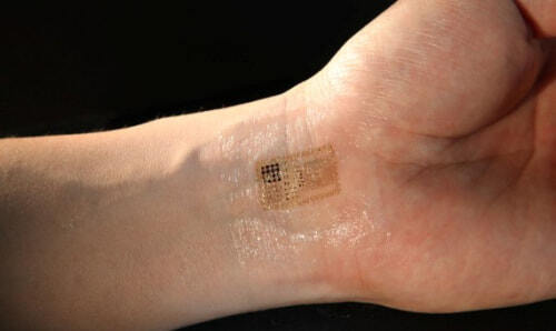 Muñeca y mano con nu chip en forma de tatuaje