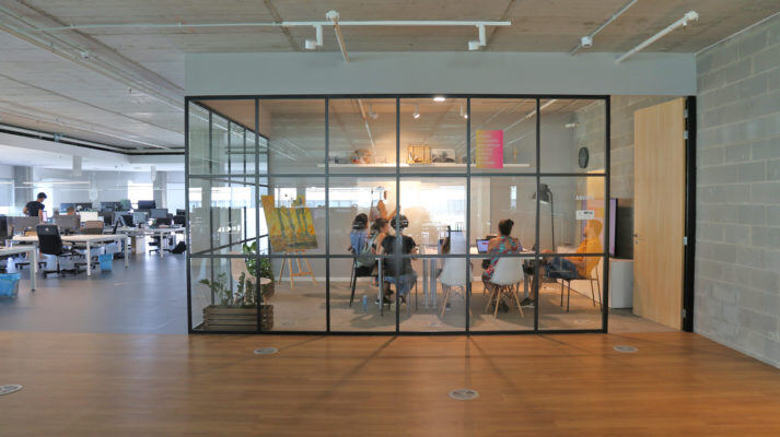Oficinas de Holaluz con trabajadores en una sala de reuniones acristalada