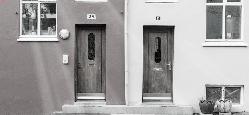 Fotografía en blanco y negro de las puertas de dos casas contiguas