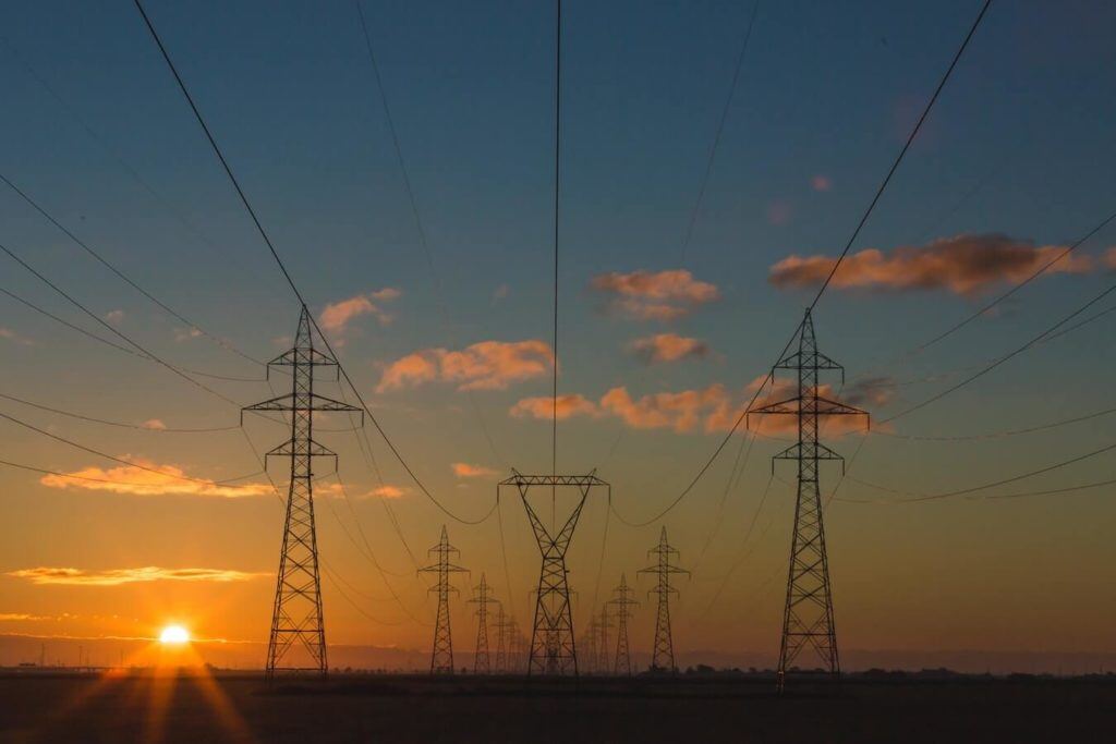 Torres eléctricas y cables de alta tensión al atardecer