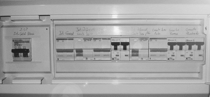 Cuadro eléctrico con interruptores y etiquetas escritas a mano