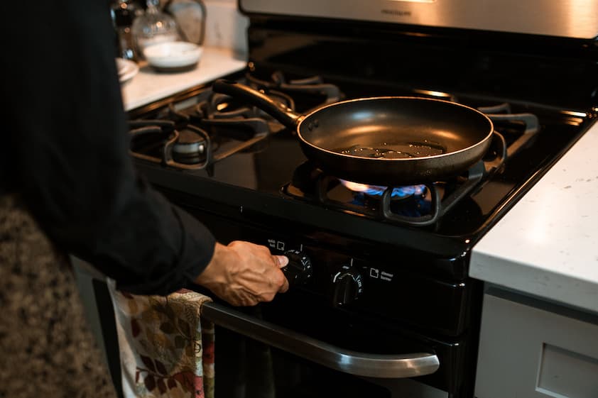 Cocinando en una estufa de gas con sartén caliente