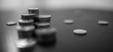 Mesa con monedas distribuidas, algunas apiladas y otras esparcidas de forma aleatoria