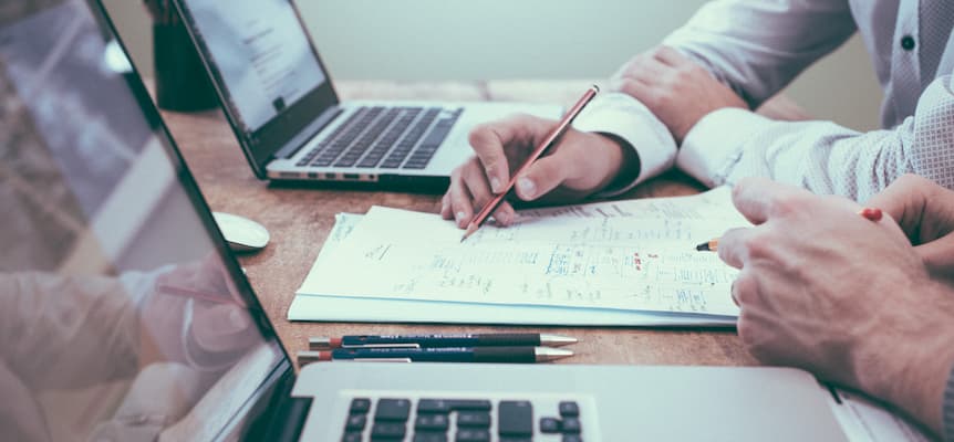 Manos y ordenadores sobre un espacio de trabajo