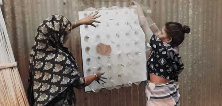 Mujeres colocando objeto en la pared