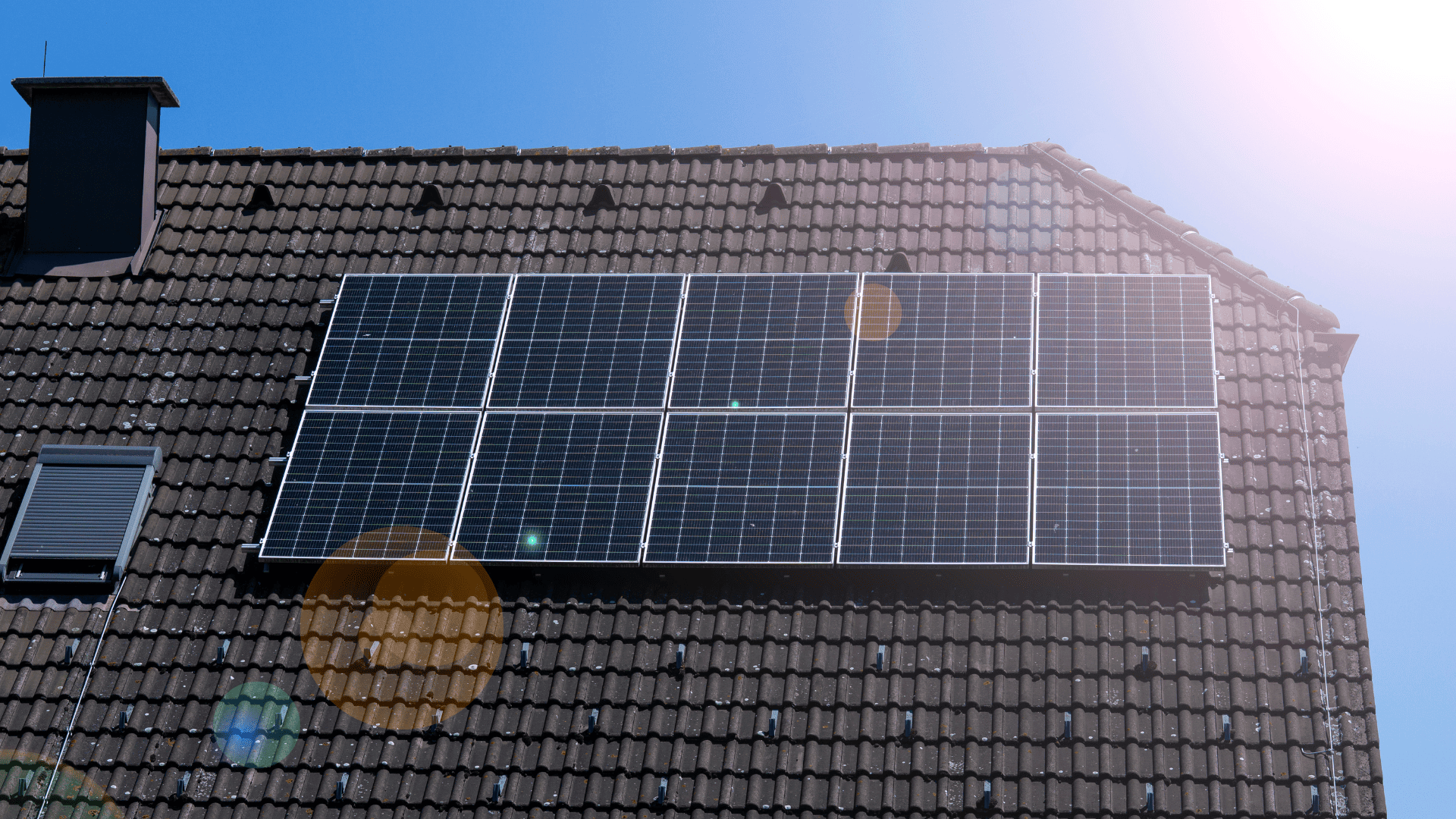 Paneles solares instalados en el tejado de una vivienda bajo un cielo azul.