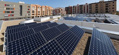 Instalación de paneles solares en las azoteas de varios edificios residenciales en una comunidad urbana.