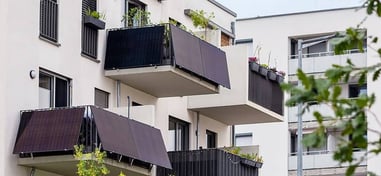 placas solares colgadas de balcones al lado de plantas