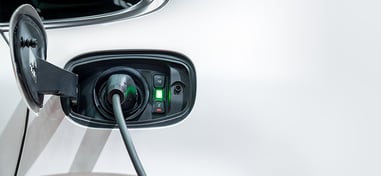 Coche eléctrico cargando mediante un conector en estación de recarga