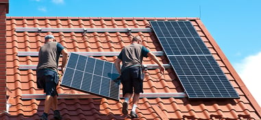 operarios instalando placas solares en un tejado