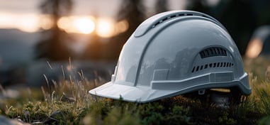 Casco de seguridad blanco sobre el suelo al atardecer