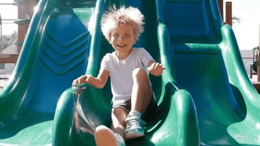 Niño saltando por un tobogán con electricidad estática