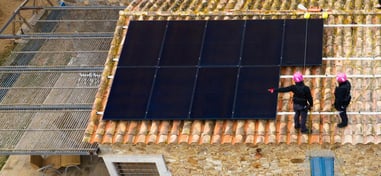 Instaladores colocando paneles solares sobre tejado de tejas