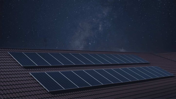 Paneles solares instalados en un tejado bajo un cielo estrellado.