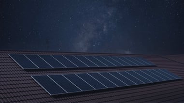 Paneles solares instalados en un tejado bajo un cielo estrellado.