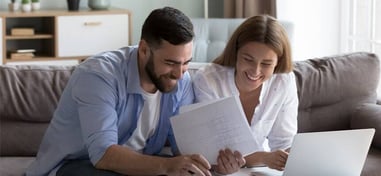 Pareja revisando una factura de la luz con un portátil
