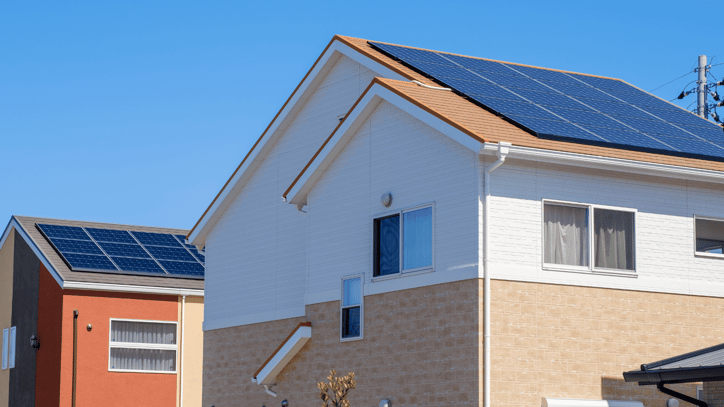 Viviendas unifamiliares con paneles solares instalados en los tejados bajo un cielo despejado.