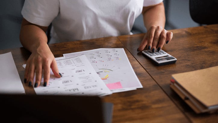 Persona revisando la factura de la luz con una calculadora