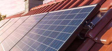 Paneles solares instalados sobre un tejado de tejas rojas.