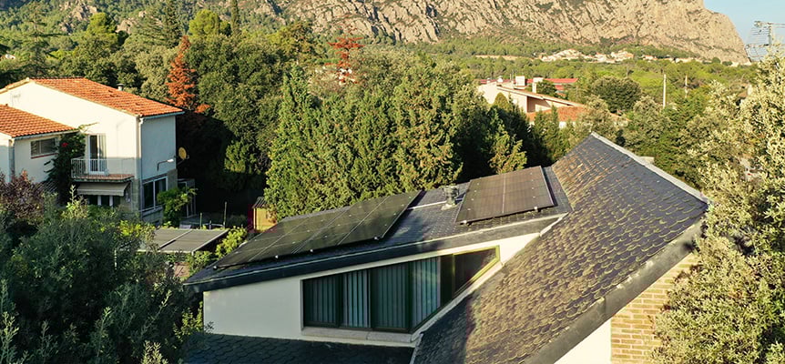 Casa con paneles solares en el tejado rodeada de naturaleza