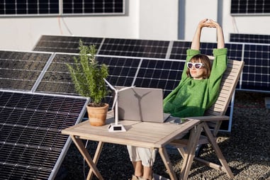 Mujer disfrutando del sol en la terraza junto a placas solares