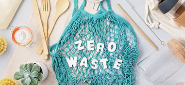 bolsa de rejilla con el texto zero waste y diferentes aparatos relacionados con la limpieza